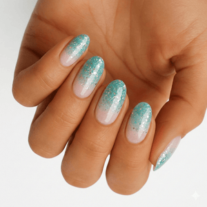 Hand wearing turquoise glitter ombre nail wraps fading from clear to sparkly finish