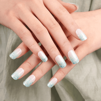 Pastel blue and pink glitter nail wraps on hands showing sparkly gradient manicure
