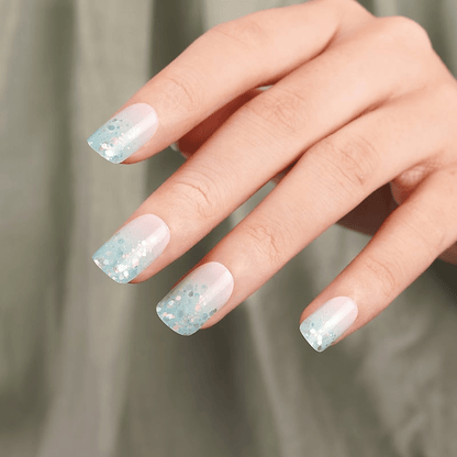 Sparkly blue and pink nail wraps on fingertips showing glittery ombre manicure