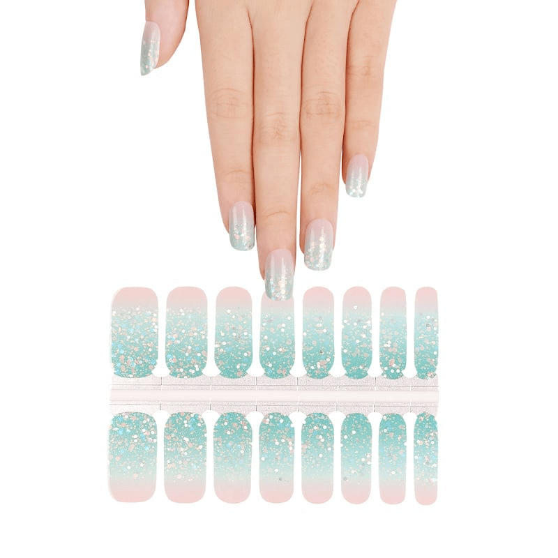 Blue pink glitter nail wrap sheets with hand showing sparkly gradient manicure design