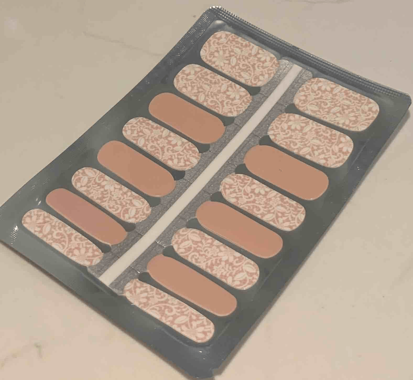 Lace pattern nail wrap strips in nude and white for at-home manicure