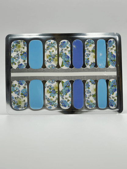 Blue and white daisy nail wrap strips in packaging showing floral pattern designs