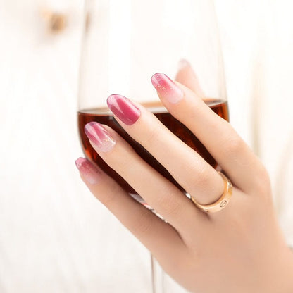Glossy pink gradient nail art wraps on manicured hand