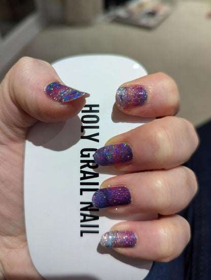 Purple glitter gradient nail wraps on hand with sparkly ombre marble finish