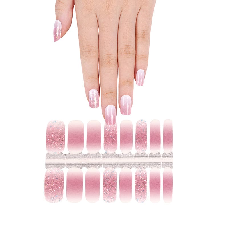 Hand wearing pink shimmer gel nail wraps with glitter gradient manicure design