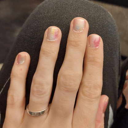 Hand wearing soft pink watercolour nail art wraps with dreamy pastel ombre finish
