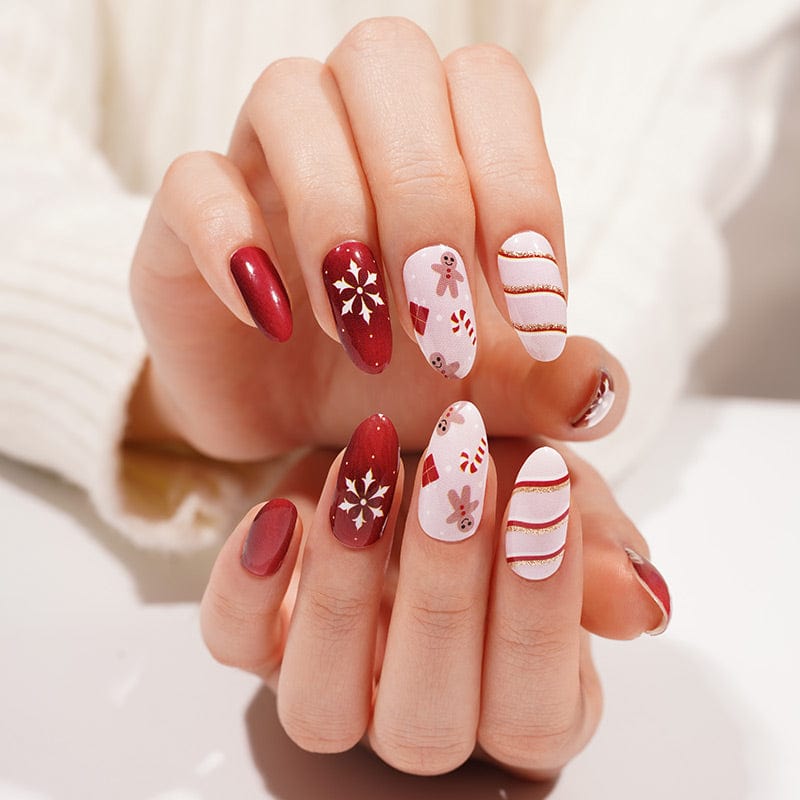 Holiday nail art featuring red and pink Christmas nail wraps with snowflake patterns