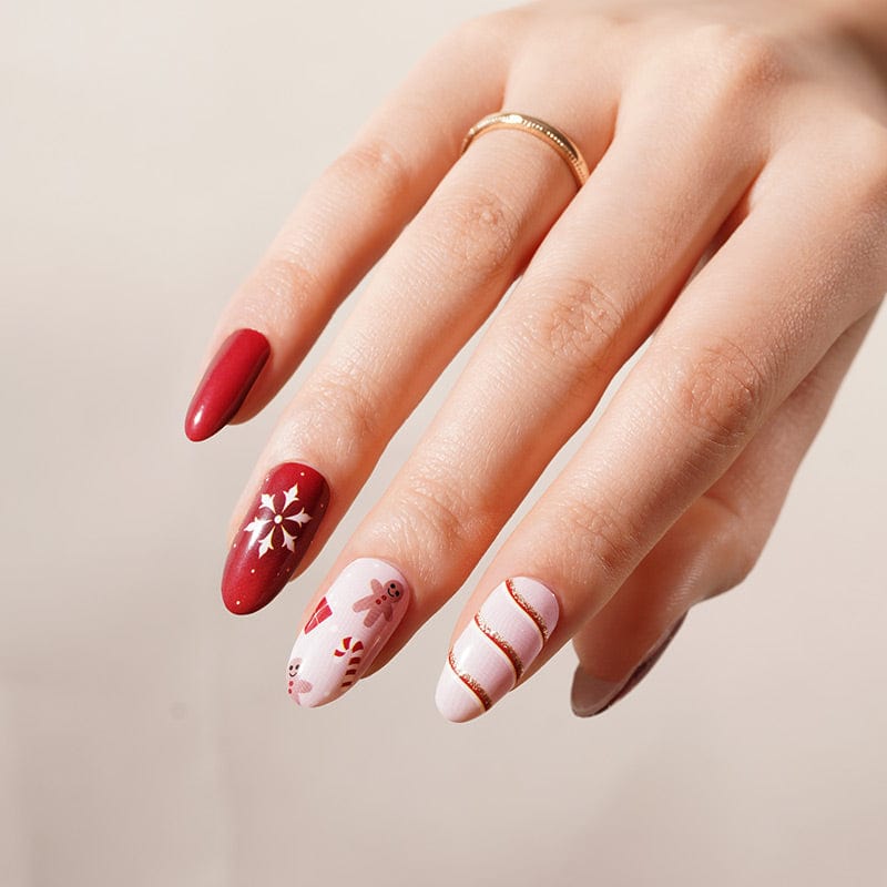 Festive red and pink nail art with gold snowflake designs for Christmas manicure