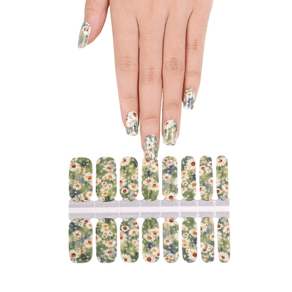 Green daisy pattern nail wraps on hand showing floral botanical design for at-home manicure