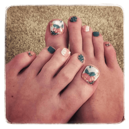 Tropical flamingo pedicure nail wraps applied on feet showing coral and teal design