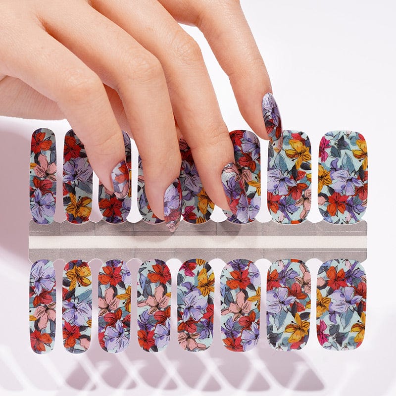 Hand touching non-UV nail wraps sheet featuring colourful vintage floral botanical pattern