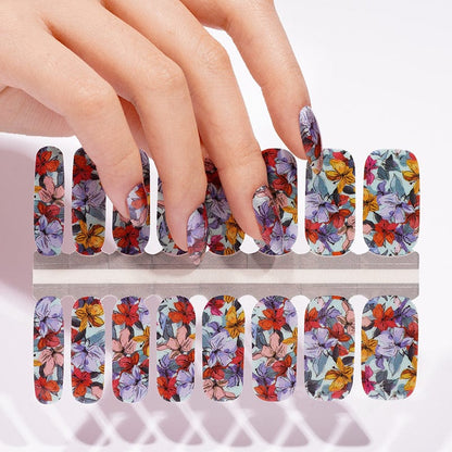 Hand touching non-UV nail wraps sheet featuring colourful vintage floral botanical pattern