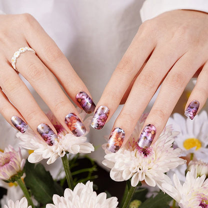 Floral watercolour nail wraps on hands with white daisies multicoloured flower pattern