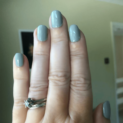 Fog grey nail wraps manicure on fingers with ring showing neutral office nails