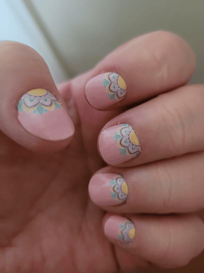 Close-up pink press-on nails with white and yellow daisy design