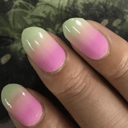 Pink green gradient ombre gel nail wraps on hand showing colour-changing hypercolour effect