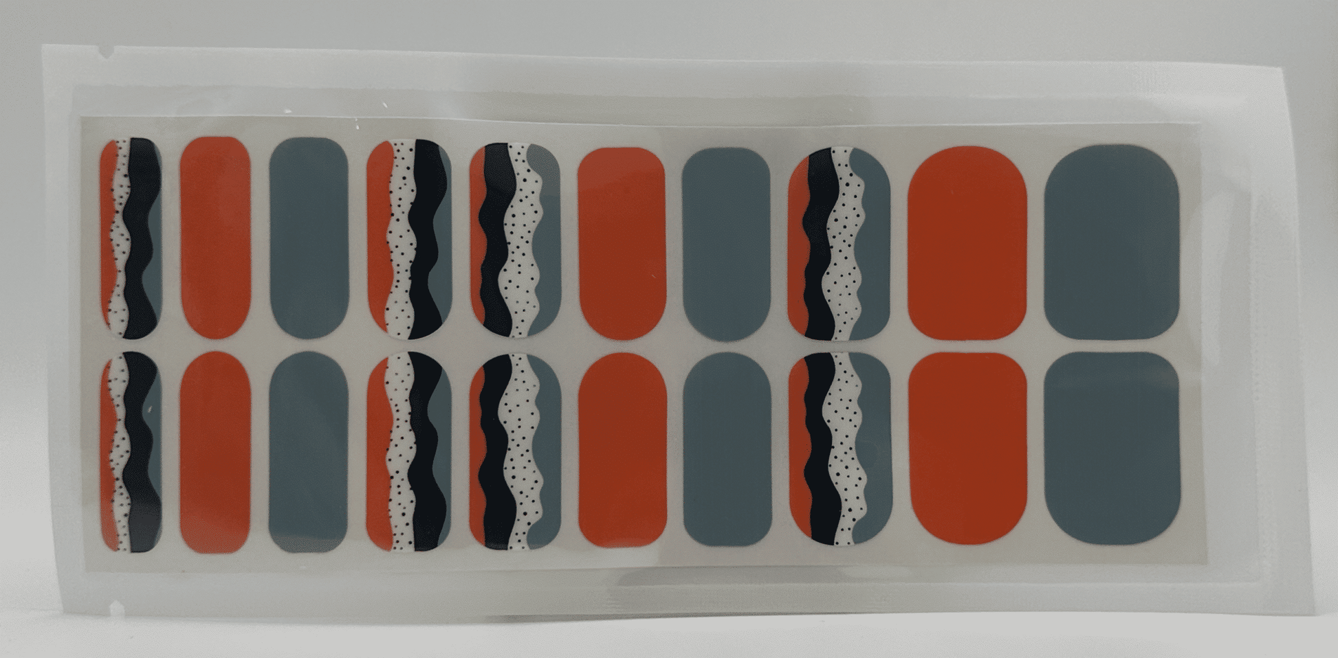 Wide fit nail wraps sheet featuring retro geometric patterns in orange blue black colours