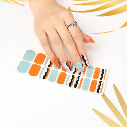 Hand displaying retro orange blue black geometric nail wraps with wavy stripes pattern