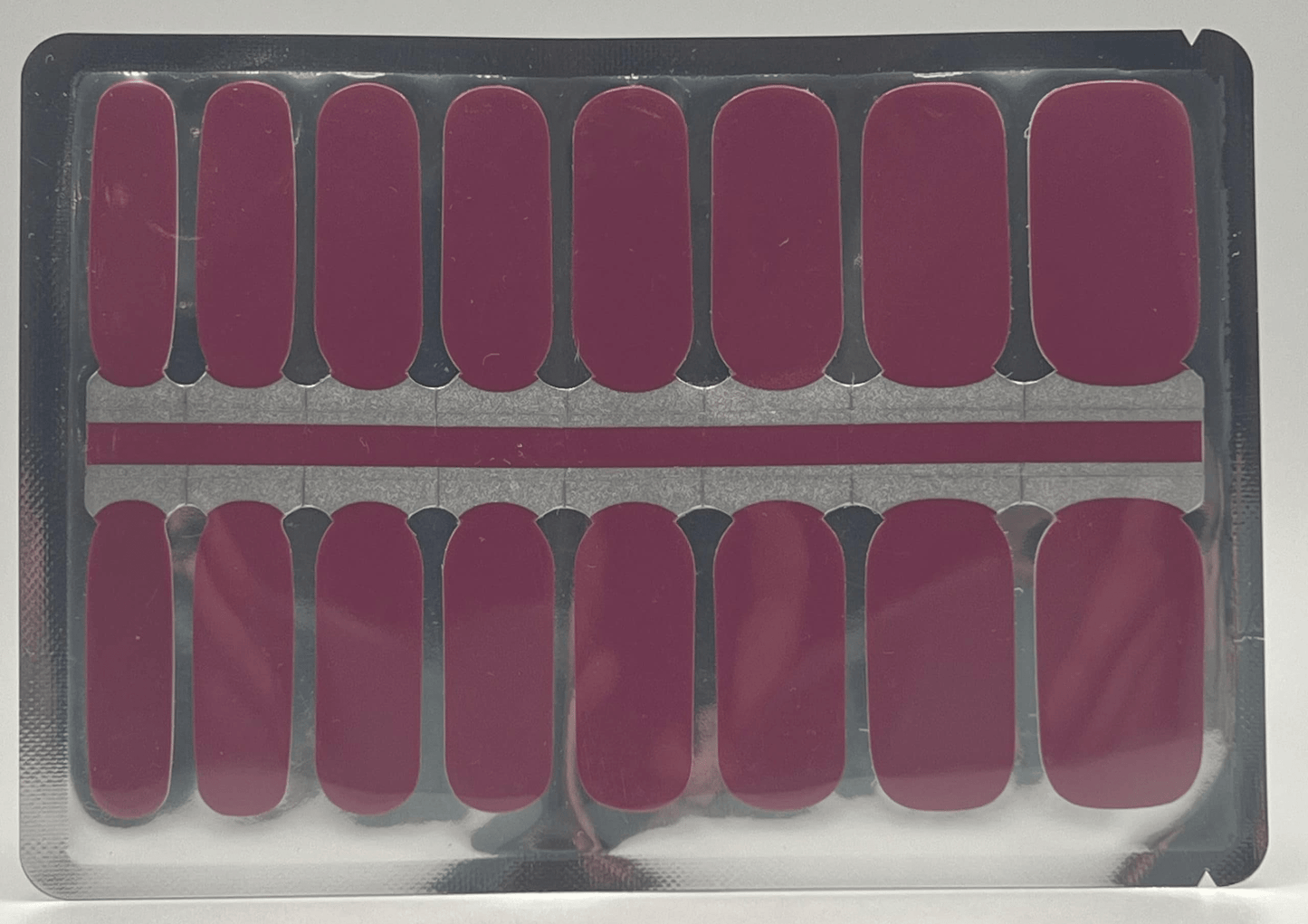 Sheet of burgundy non-UV nail wraps showing multiple sizes for at-home manicure