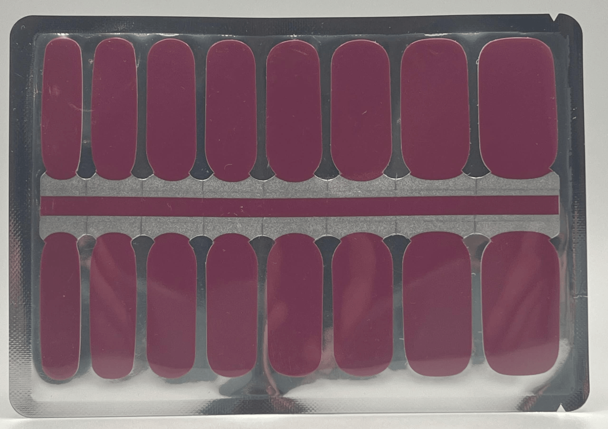 Sheet of burgundy non-UV nail wraps showing multiple sizes for at-home manicure