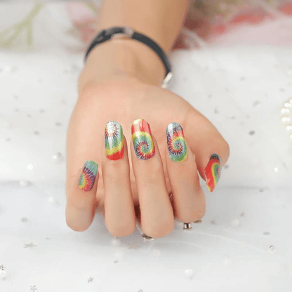 Colourful tie-dye nail wraps on hand showing rainbow swirl patterns for retro manicure