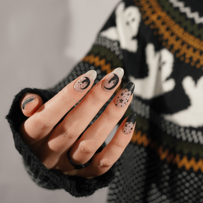 Halloween gel nail wraps with black glitter moons and stars on hand