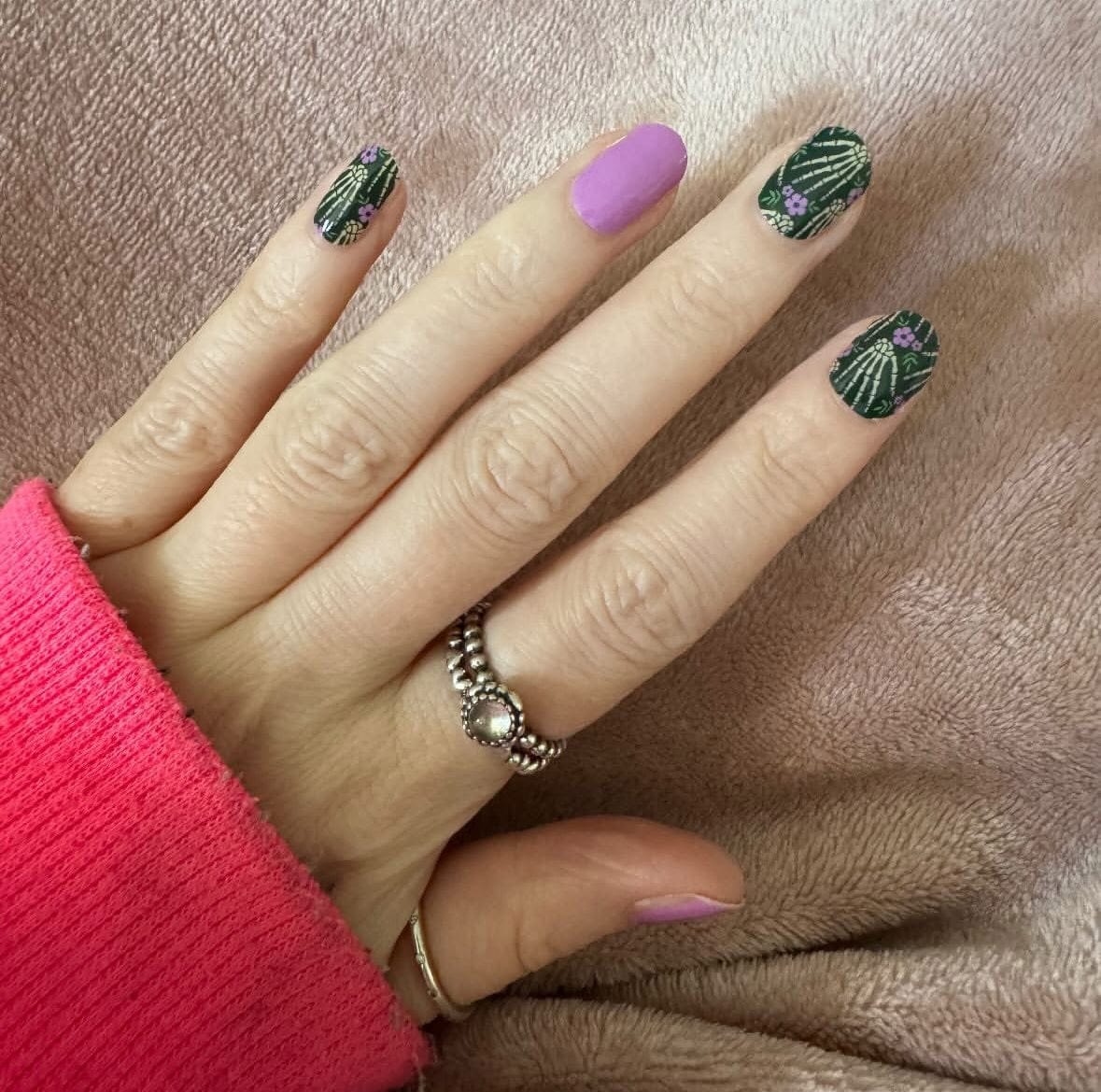 Halloween skull bone nail wraps in black with purple accent nails on hand