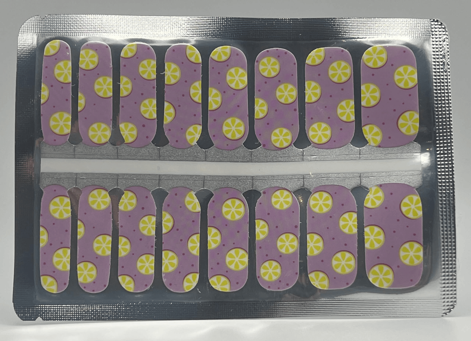 Pink nail wraps with yellow citrus lemon pattern in packaging for DIY nail art