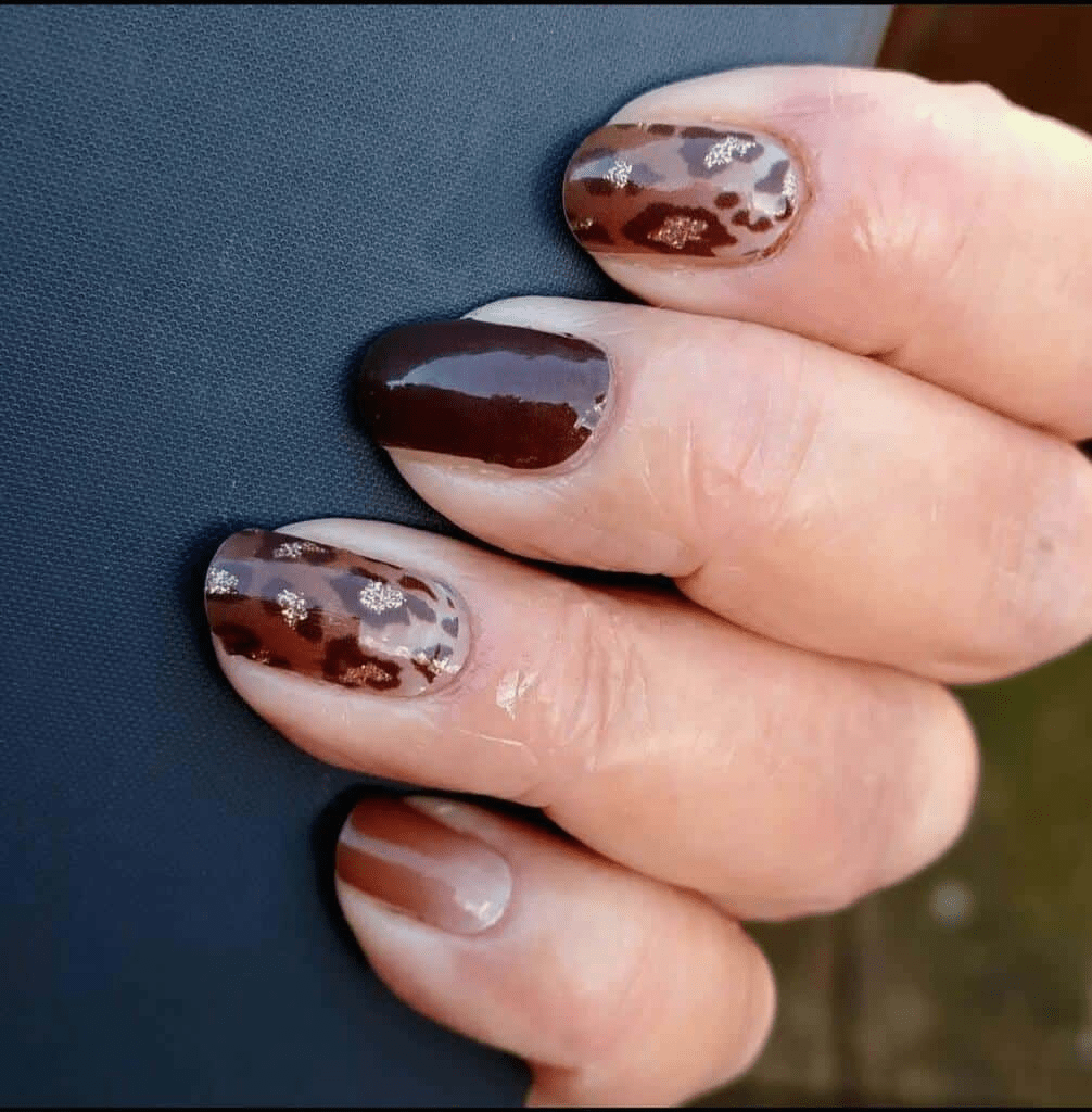 Glossy brown nail wraps with leopard print pattern applied on fingernails
