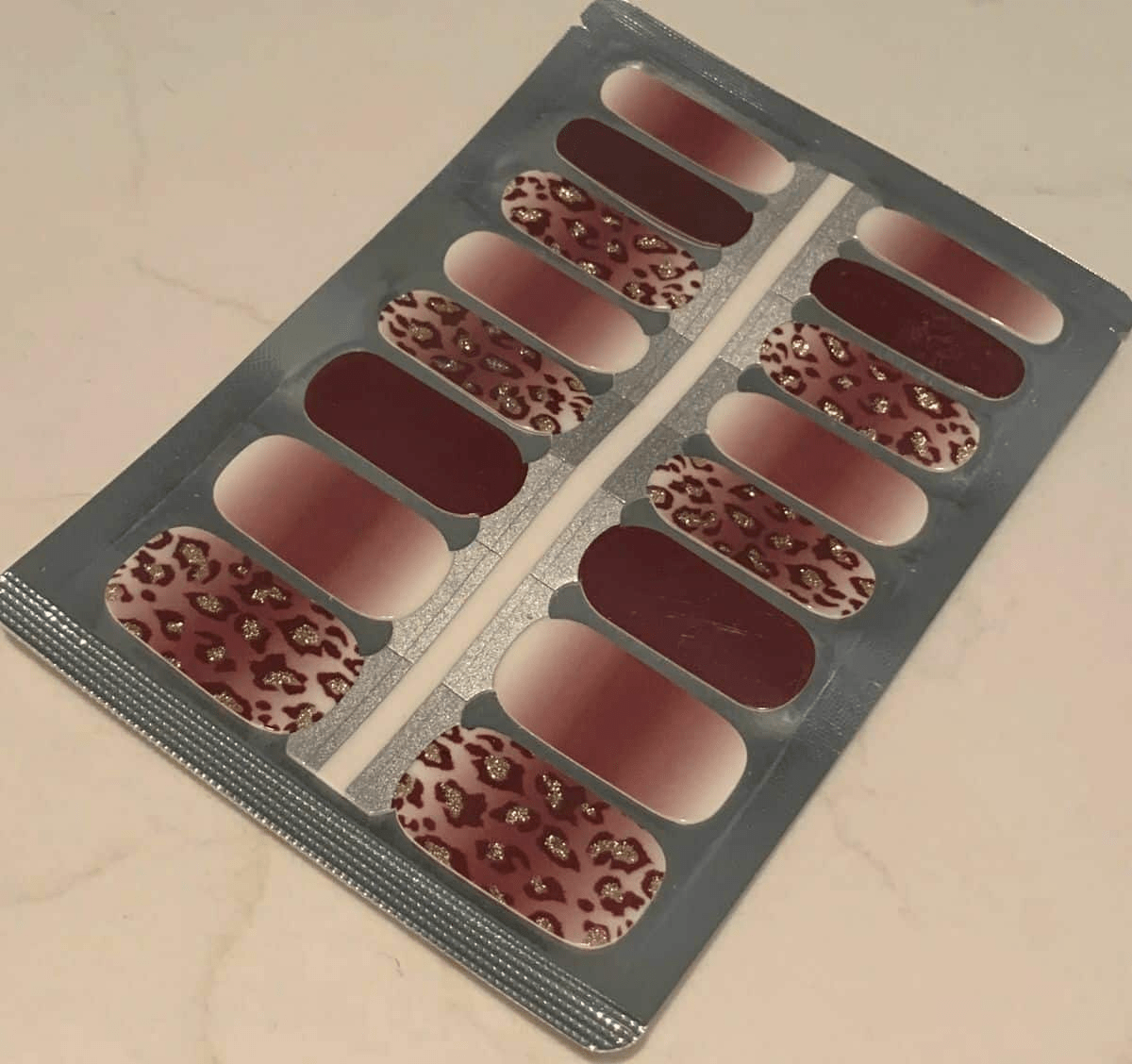 Non-UV nail wraps sheet featuring brown leopard print designs with gold metallic spots