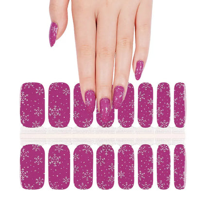 Purple glitter nail wraps with white snowflake pattern shown on hand with product sheet