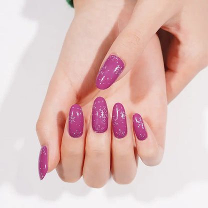 Festive purple glitter nail art wraps with white snowflake design on hand