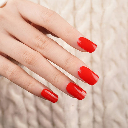 Hand wearing glossy cherry red nail wraps for classic at-home manicure