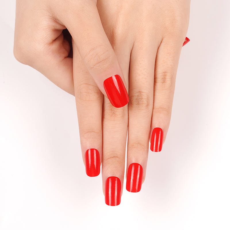 Hands displaying bright red glossy nail wraps for DIY manicure
