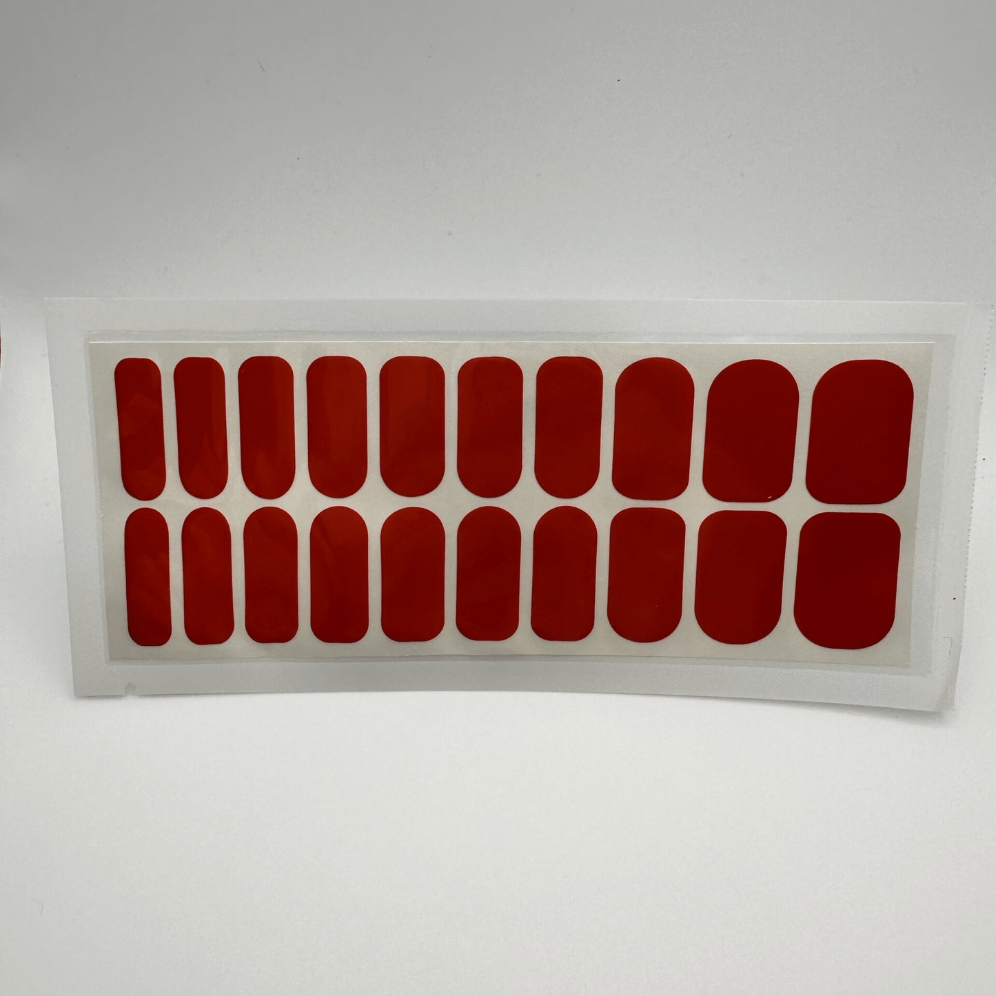 Sheet of twenty cherry red glossy wide fit nail wraps in clear packaging