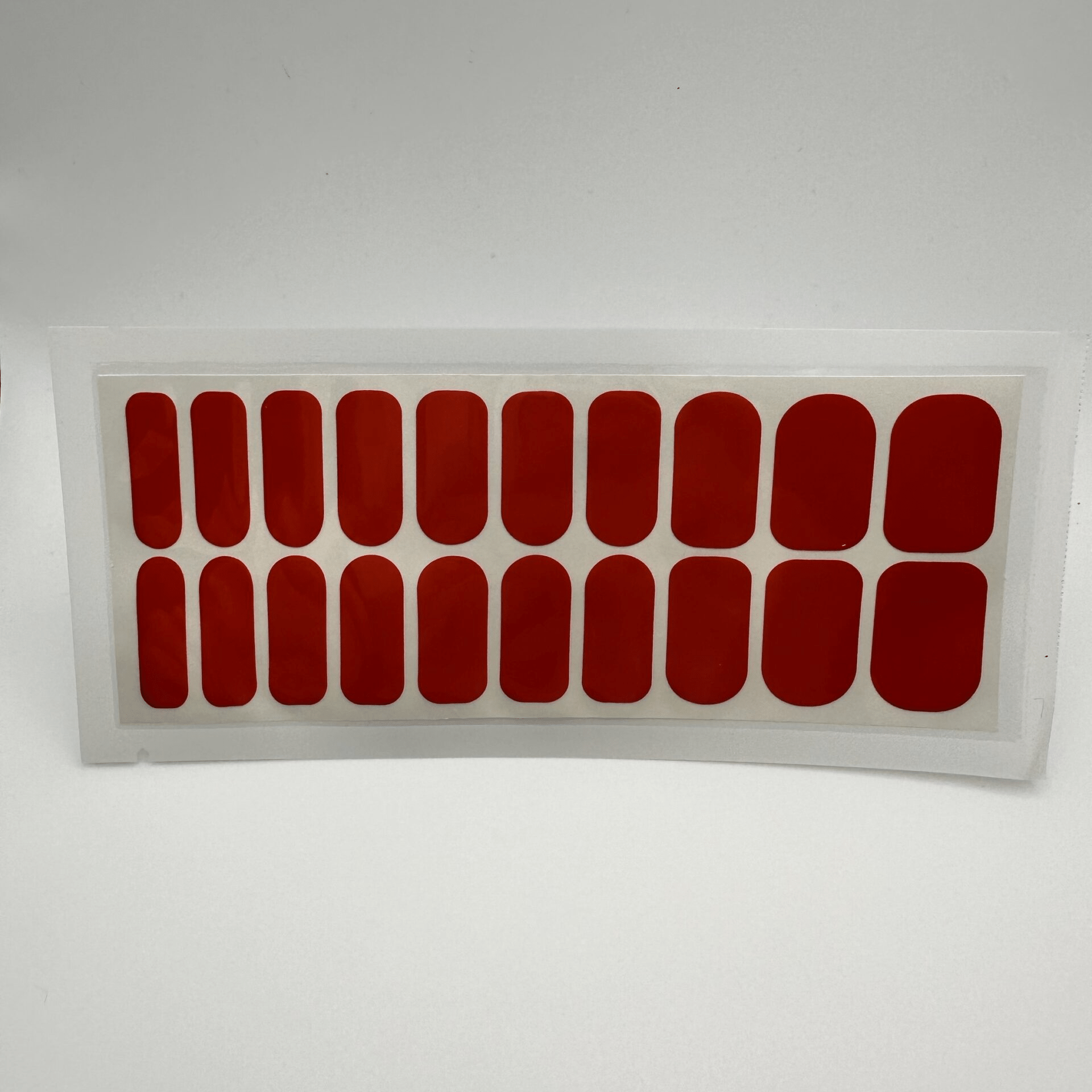 Sheet of twenty cherry red glossy wide fit nail wraps in clear packaging