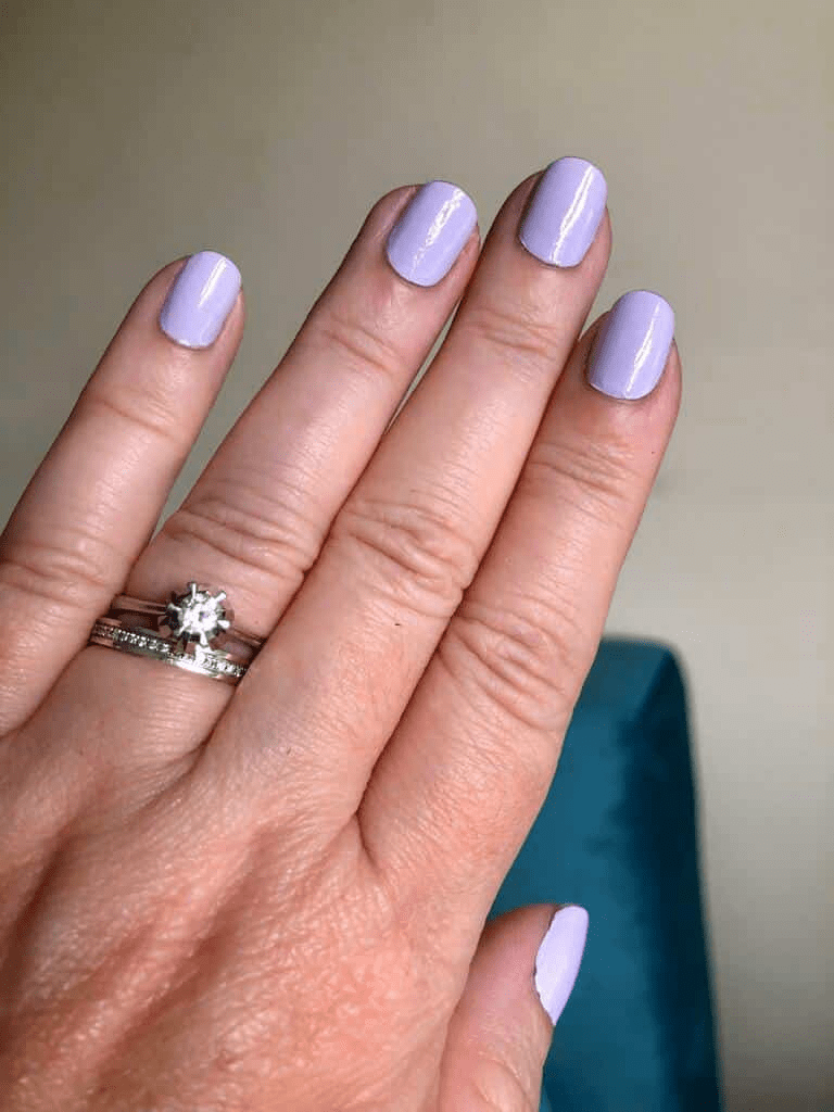 Hand with lavender purple non-UV nail wraps showing pastel spring manicure style