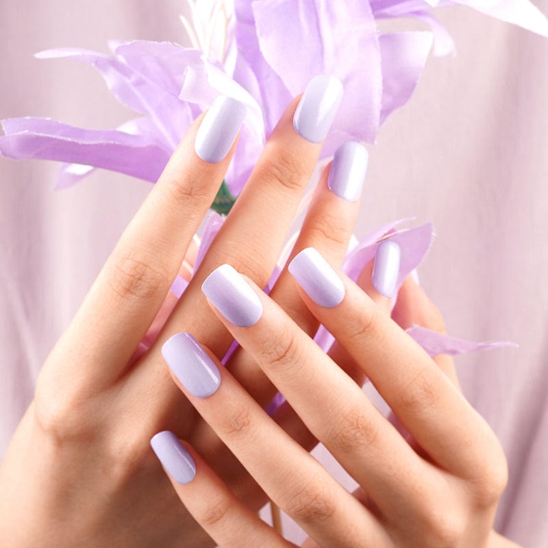 Lilac purple nail wraps on hands with flowing purple ribbon accent