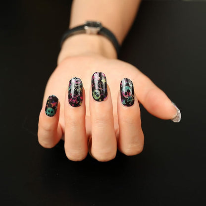 Gothic skull nail art on hand with holographic rainbow glitter effect