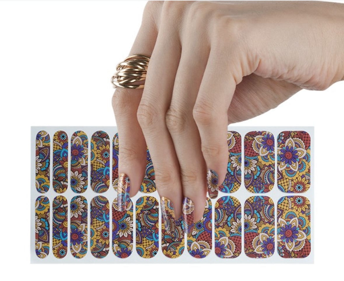 Hand applying Liberty print nail wraps with colourful botanical design from 22-piece set