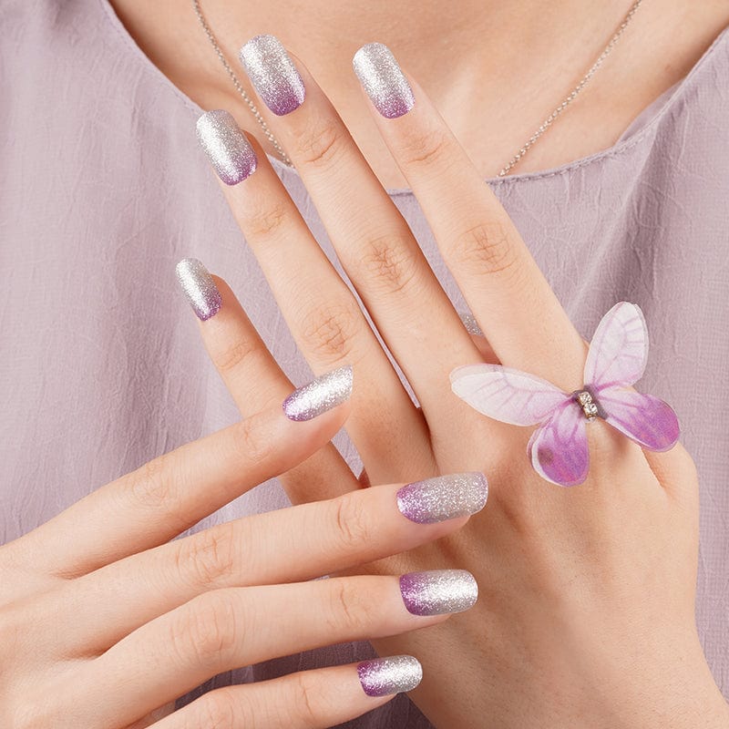 Lilac ombre shimmer nail wraps on hands with purple butterfly accent nail art