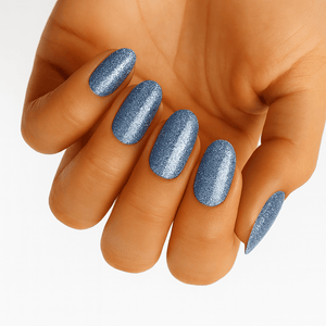 Hand showing blue glitter nail wraps with shimmer metallic finish manicure