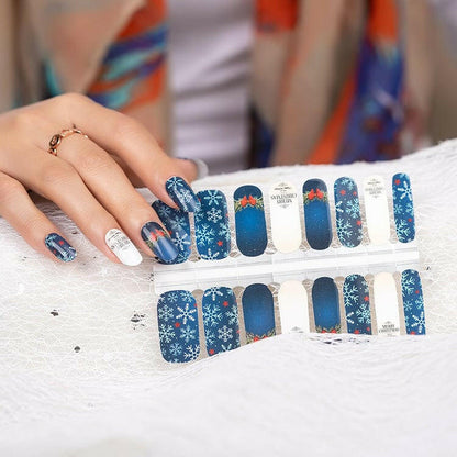 Sheet of blue Christmas nail wraps with snowflake patterns and holiday designs for at-home manicure