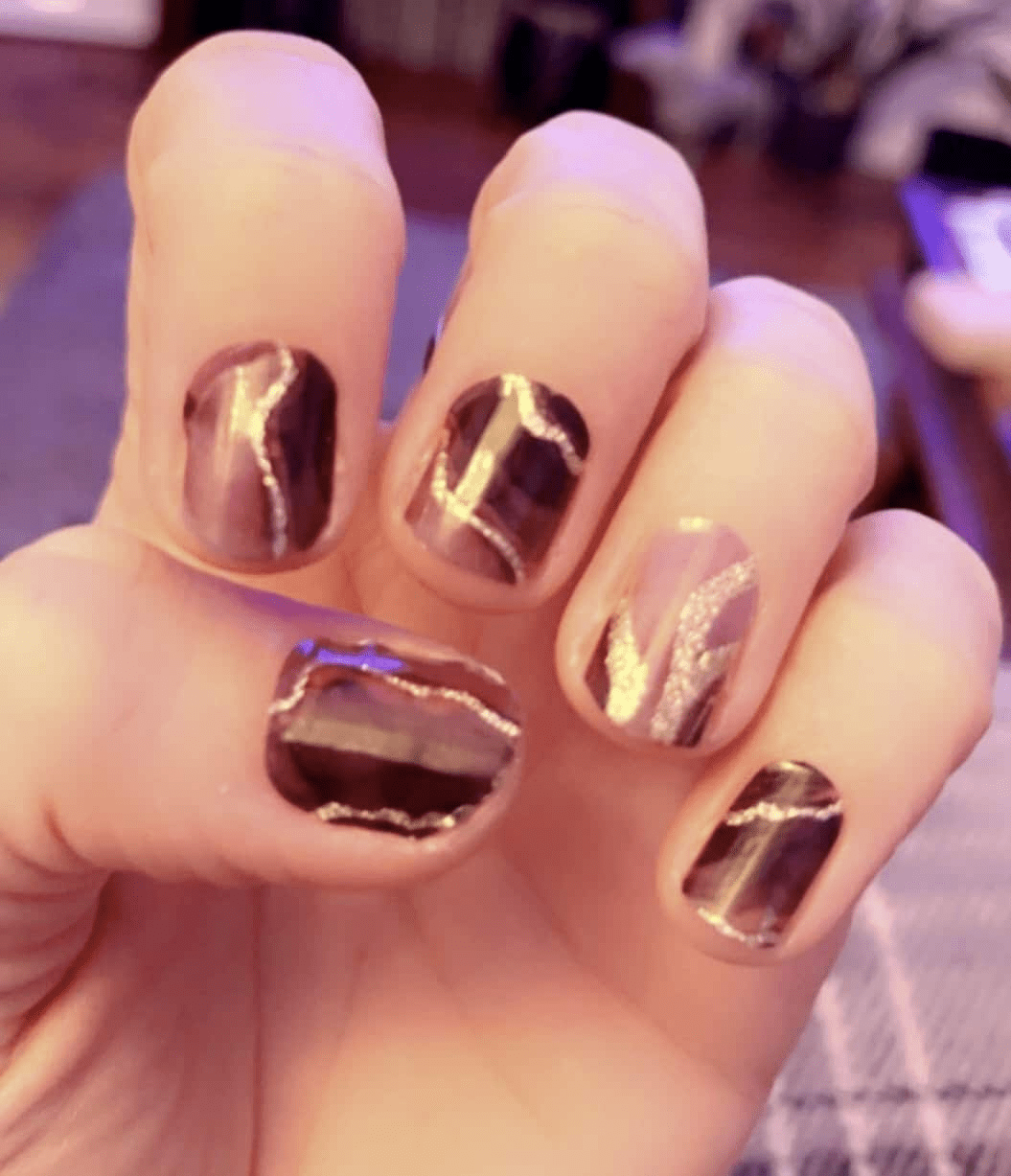 Black marble gel nail wraps with metallic gold veining creating luxe manicure