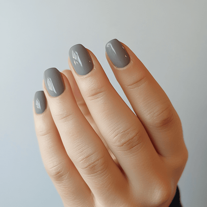 Charcoal grey nail wraps on hand displaying sophisticated solid colour manicure