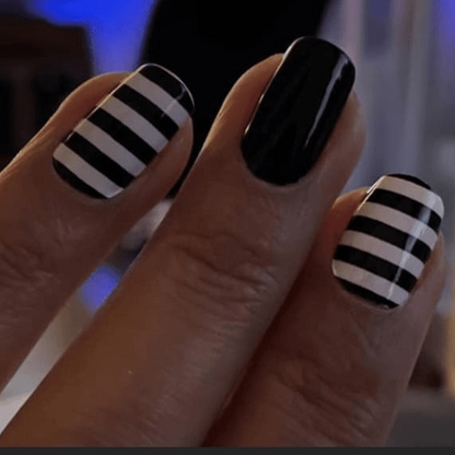 Close up hand showing black and white striped nail art wraps