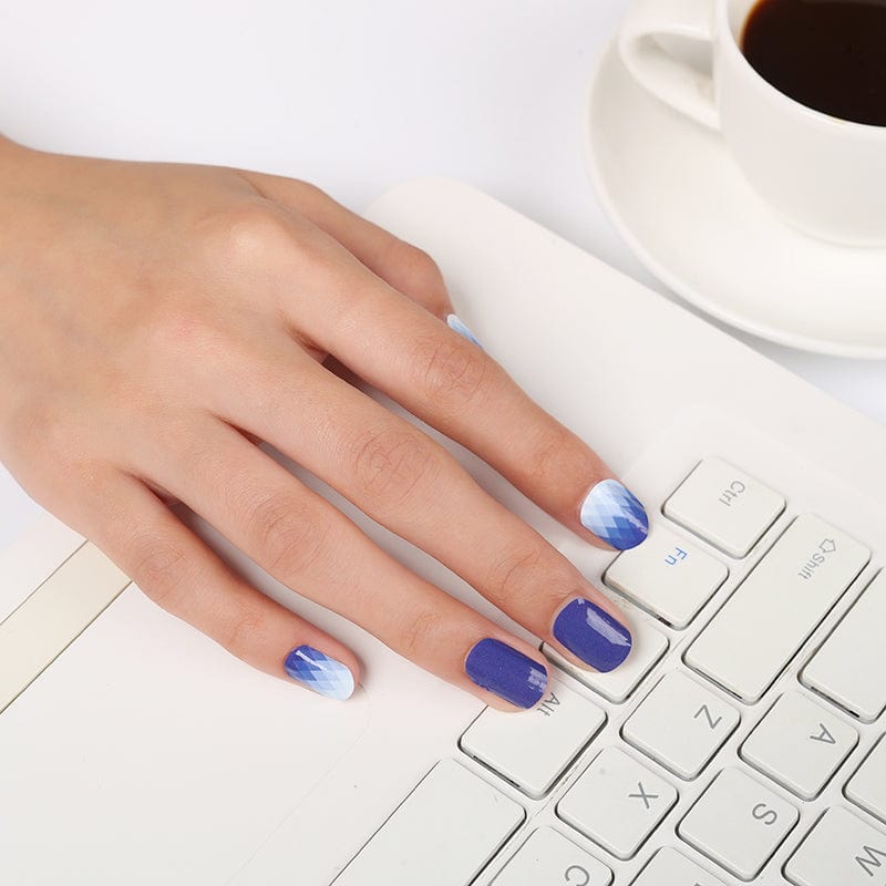 Blue to white ombre gel nail wraps on hand typing at keyboard for office manicure