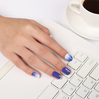 Blue to white ombre gel nail wraps on hand typing at keyboard for office manicure