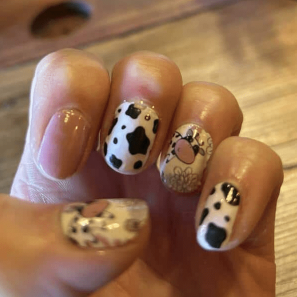 Kawaii cow nail wraps on fingernails featuring adorable cartoon farm animal designs