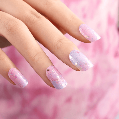 Pink gradient gel nail wraps with metallic dots applied on natural nails manicure